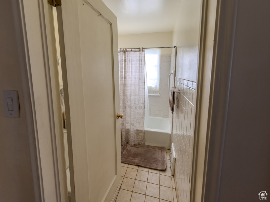 Full bathroom featuring tile patterned flooring and shower / bath combo with shower curtain