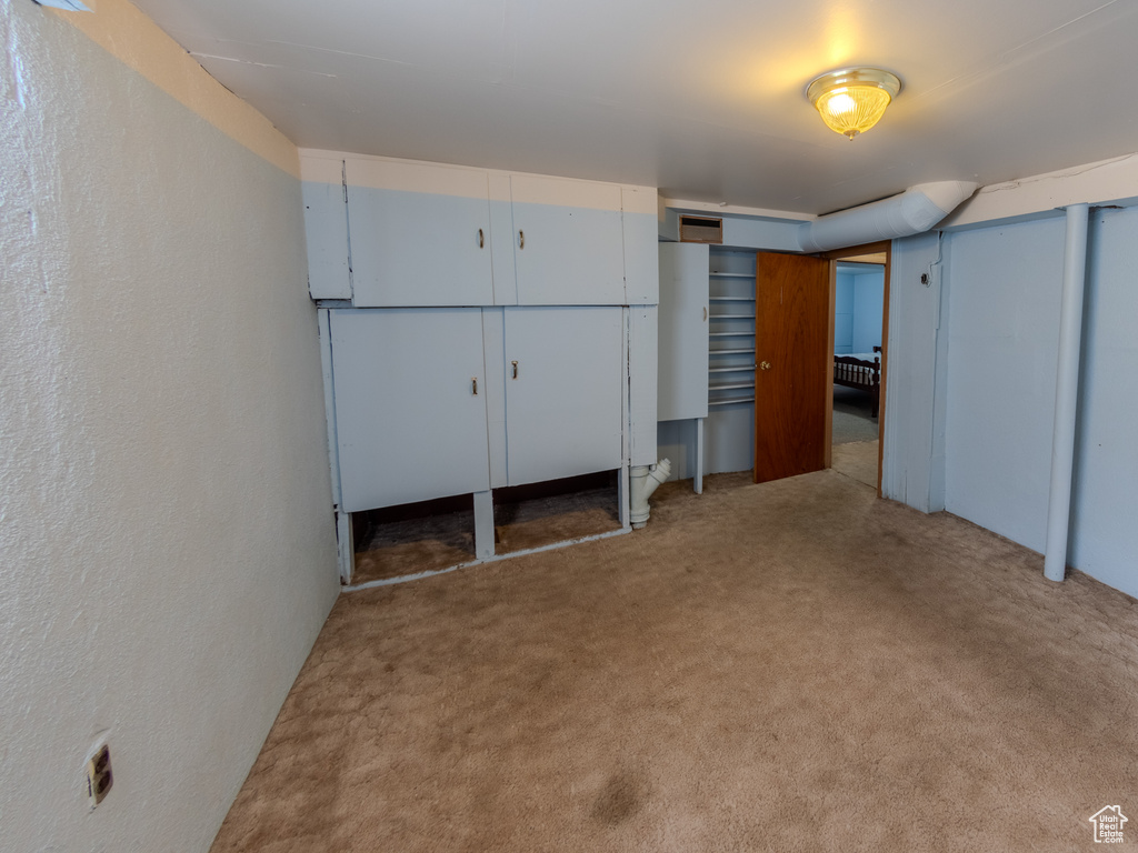 Unfurnished bedroom featuring carpet flooring, multiple closets, and a textured wall
