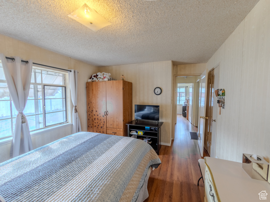 Bedroom featuring a textured ceiling and wood finished floors