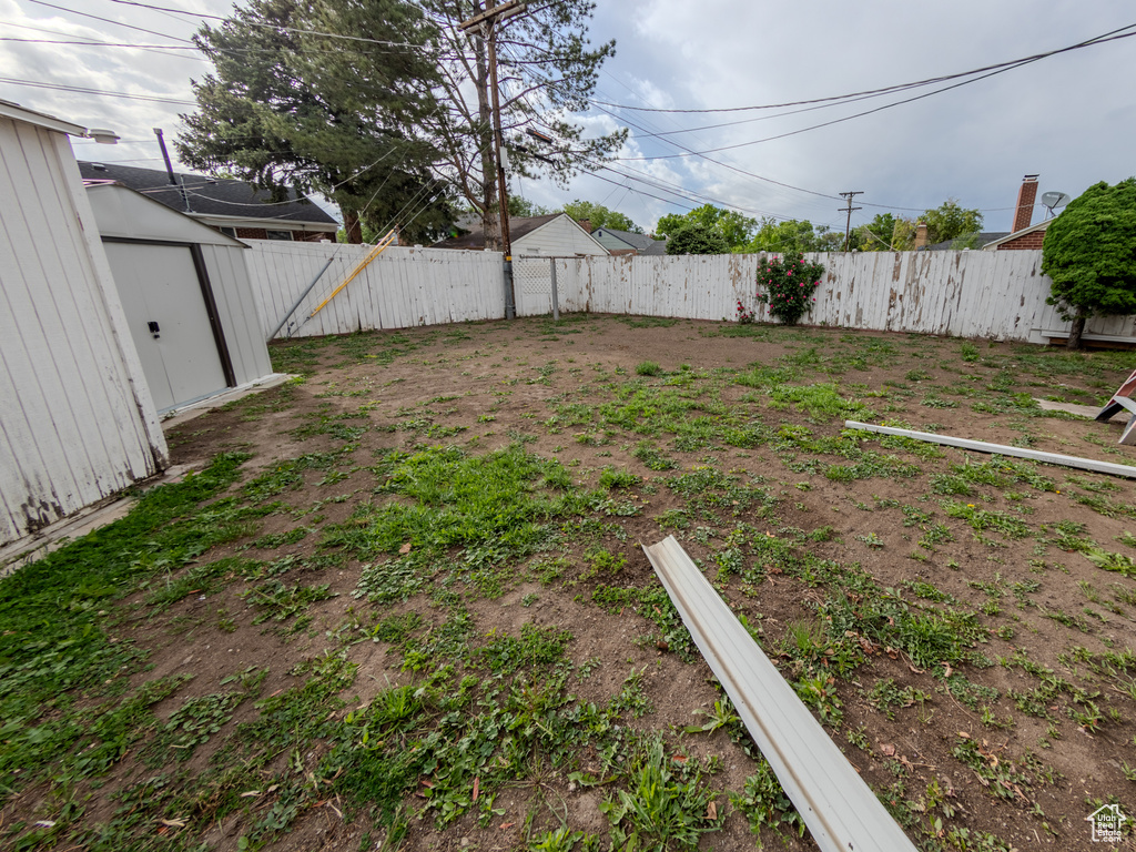 Fenced backyard with a storage unit and an outbuilding
