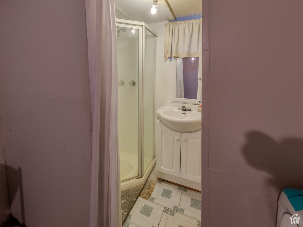 Bathroom featuring a shower stall, vanity, and tile patterned floors