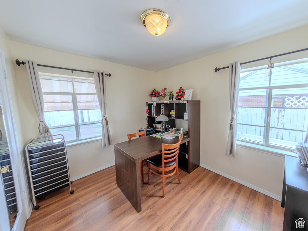 Home office with light wood-style flooring and baseboards