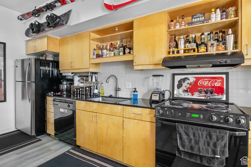 Kitchen with black appliances, a sink, open shelves, and under cabinet range hood