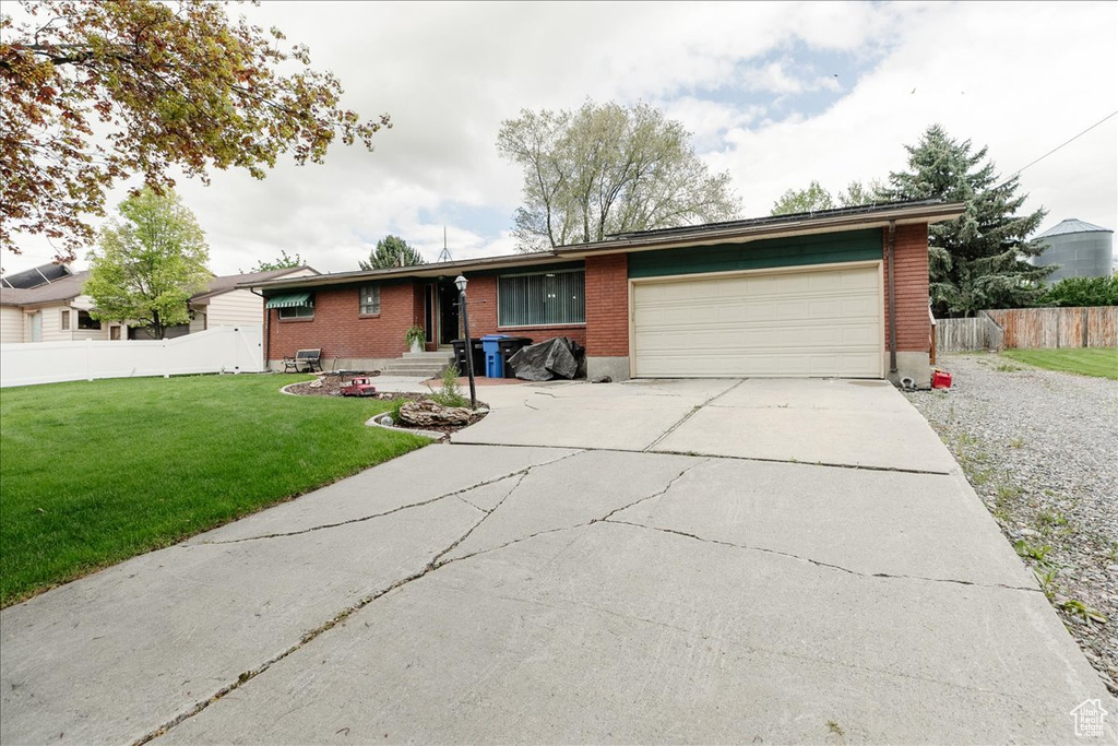 Single story home with concrete driveway, a garage, and brick siding