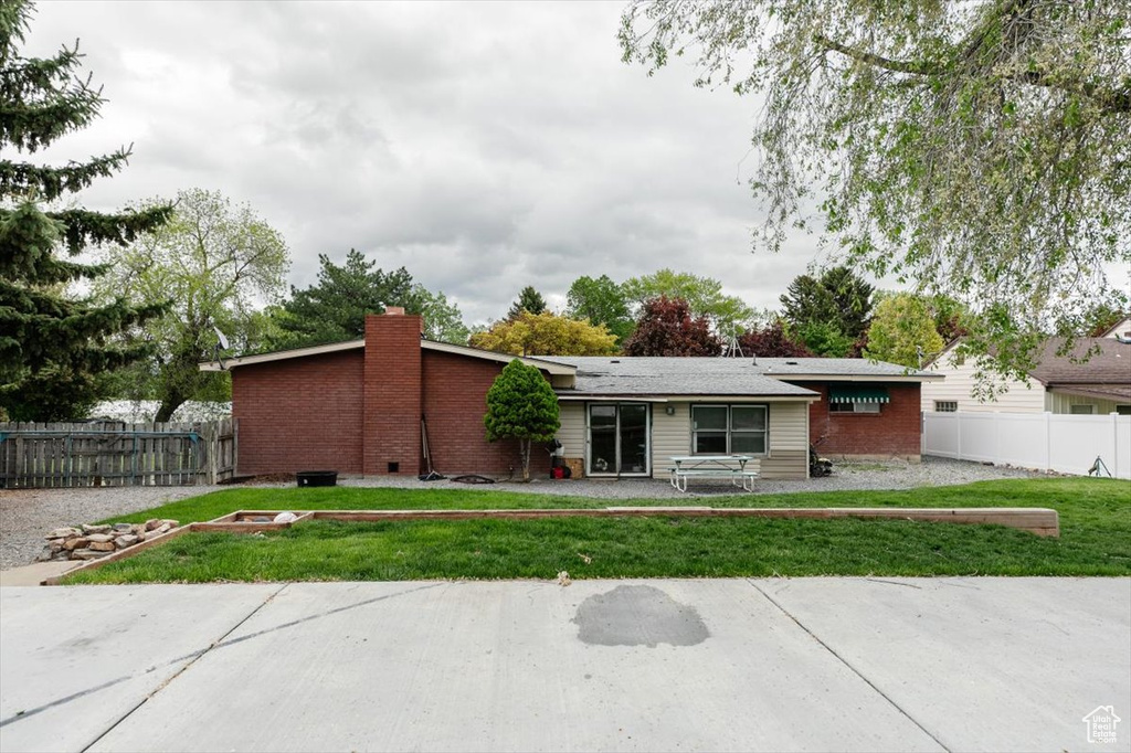 View of front of home featuring a chimney and brick siding