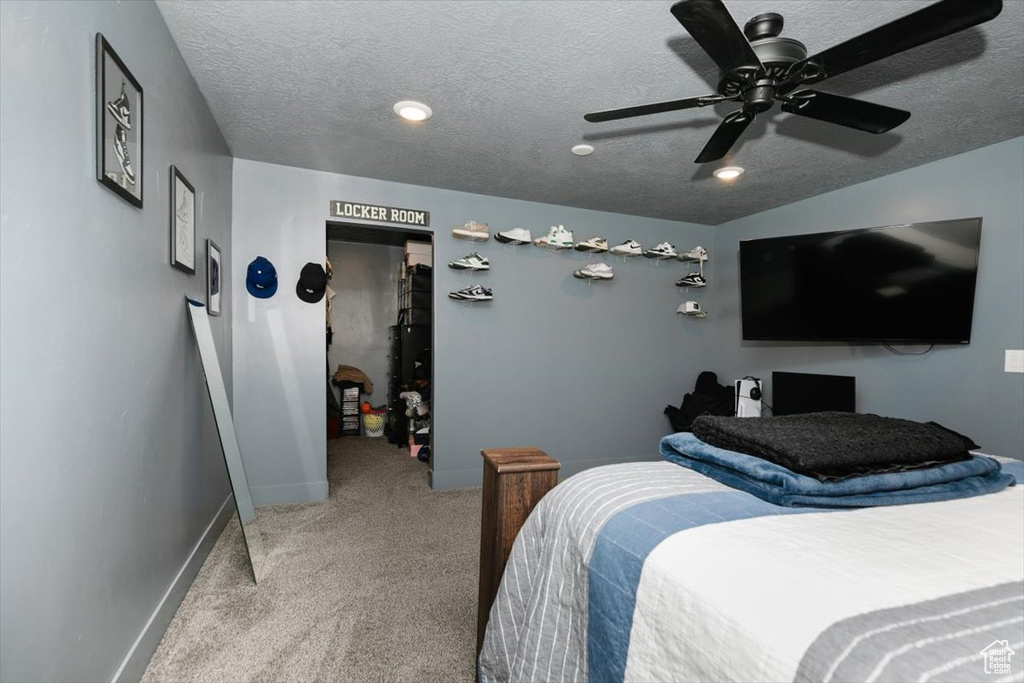 Bedroom with carpet, a textured ceiling, baseboards, and a ceiling fan