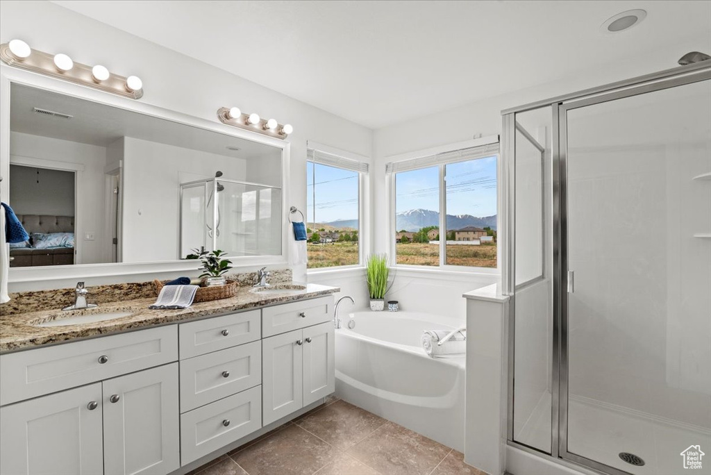 Ensuite bathroom with a shower stall, double vanity, a garden tub, and tile patterned floors