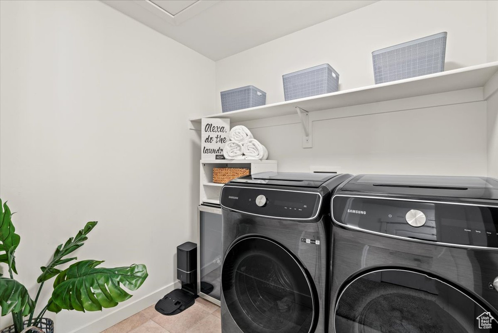 Laundry area featuring independent washer and dryer, baseboards, and tile patterned floors