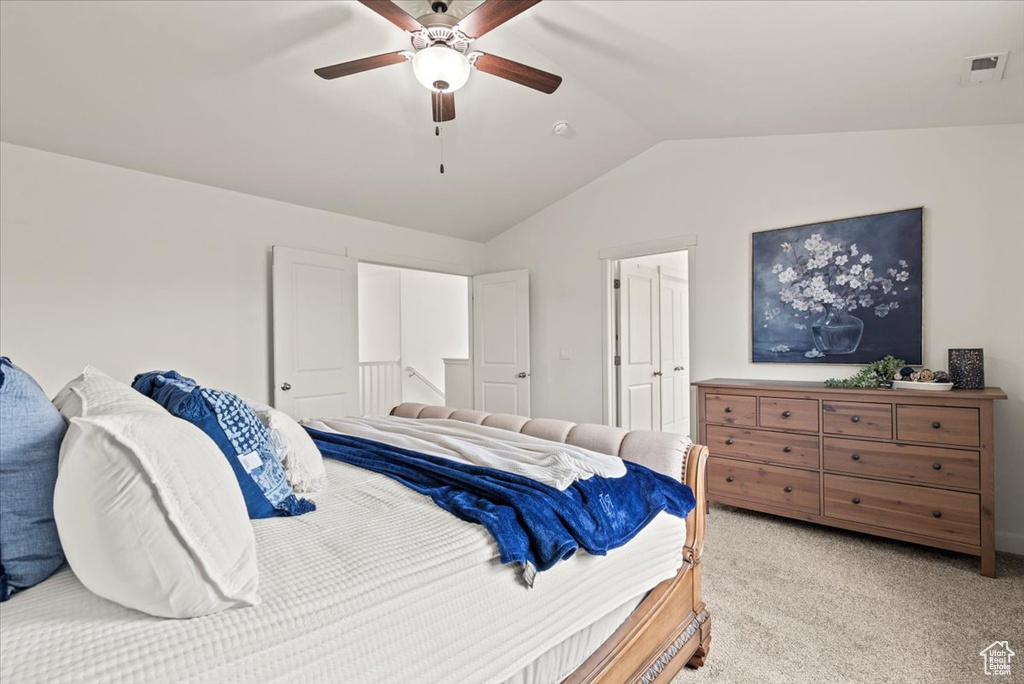 Bedroom with lofted ceiling, light carpet, and ceiling fan