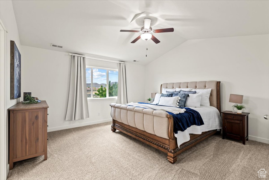 Bedroom featuring lofted ceiling, light carpet, baseboards, and a ceiling fan