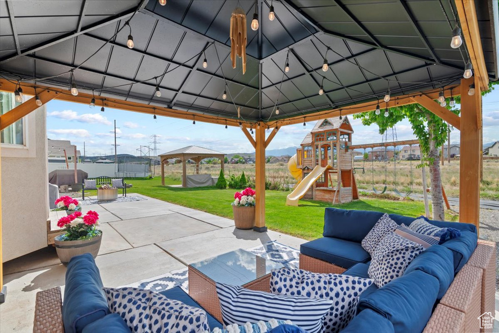 View of patio with a gazebo, an outdoor hangout area, and a playground