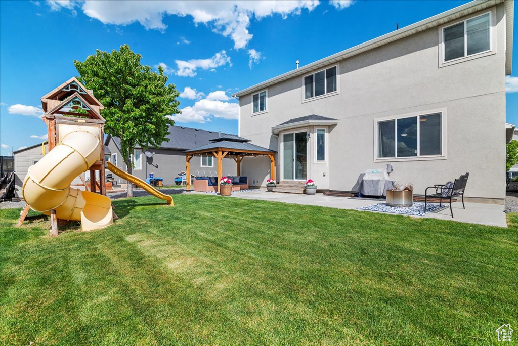 Back of house with an outdoor hangout area, a patio area, a yard, and a playground