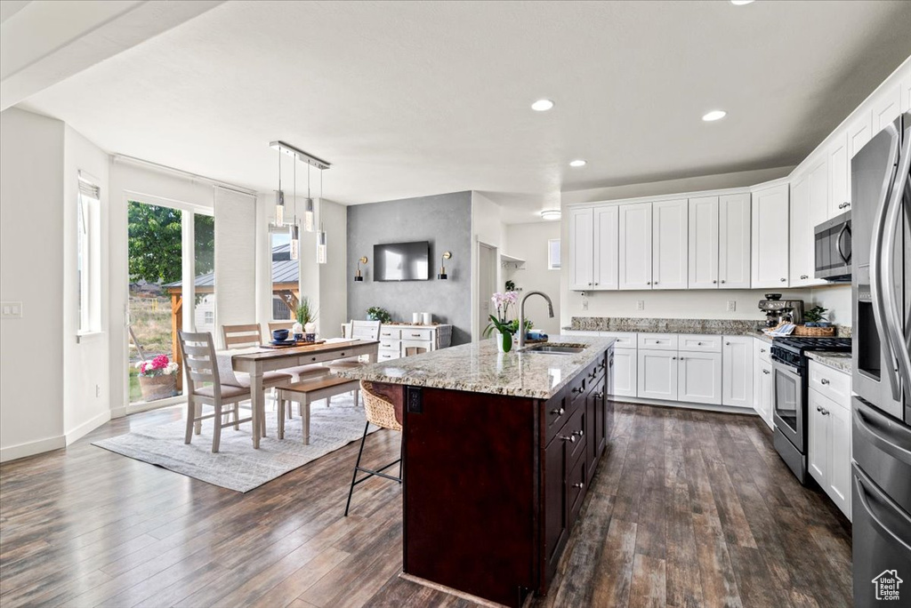 Kitchen featuring stainless steel appliances, a sink, dark wood-style floors, white cabinets, and recessed lighting
