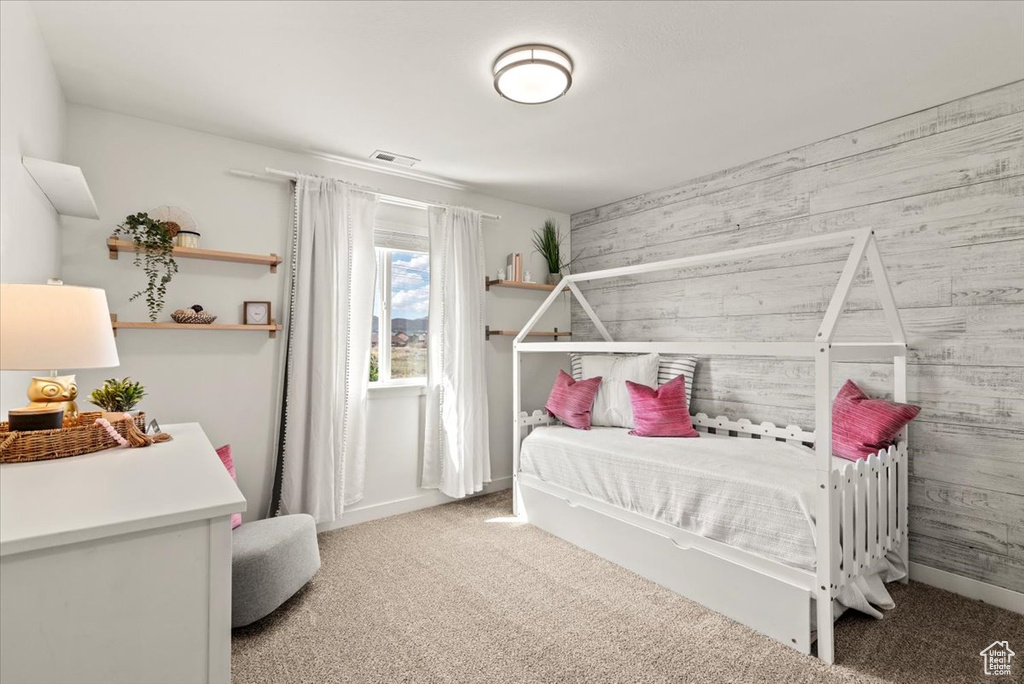 Carpeted bedroom with wood walls