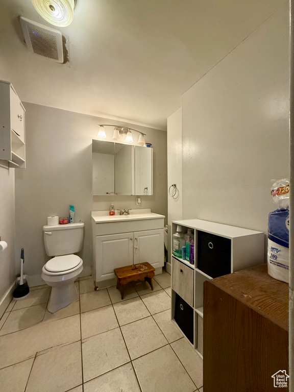 Bathroom featuring tile patterned floors, toilet, and vanity