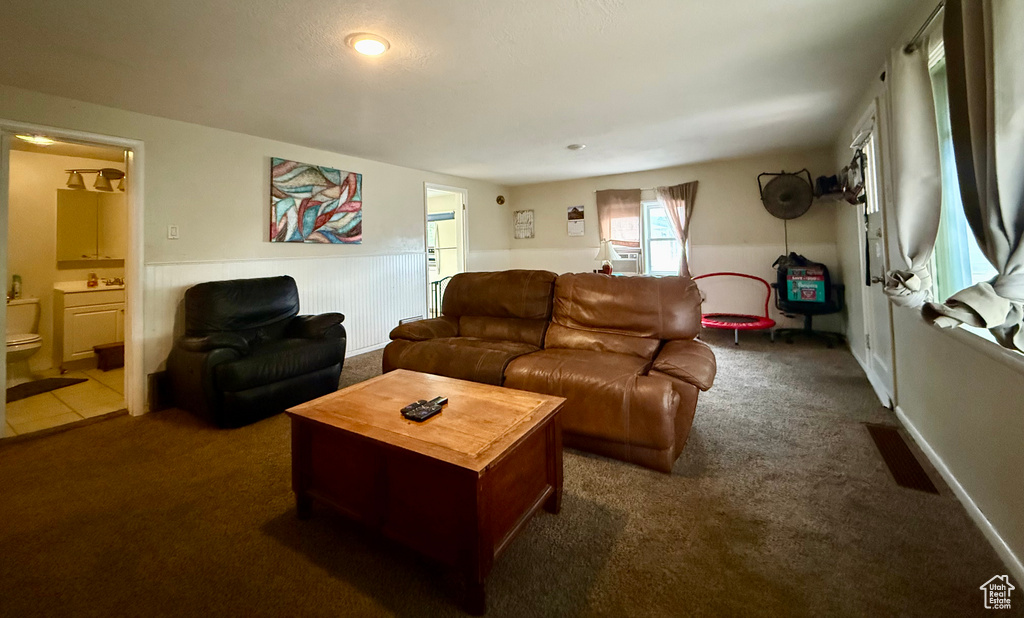 Living area with dark colored carpet and cooling unit