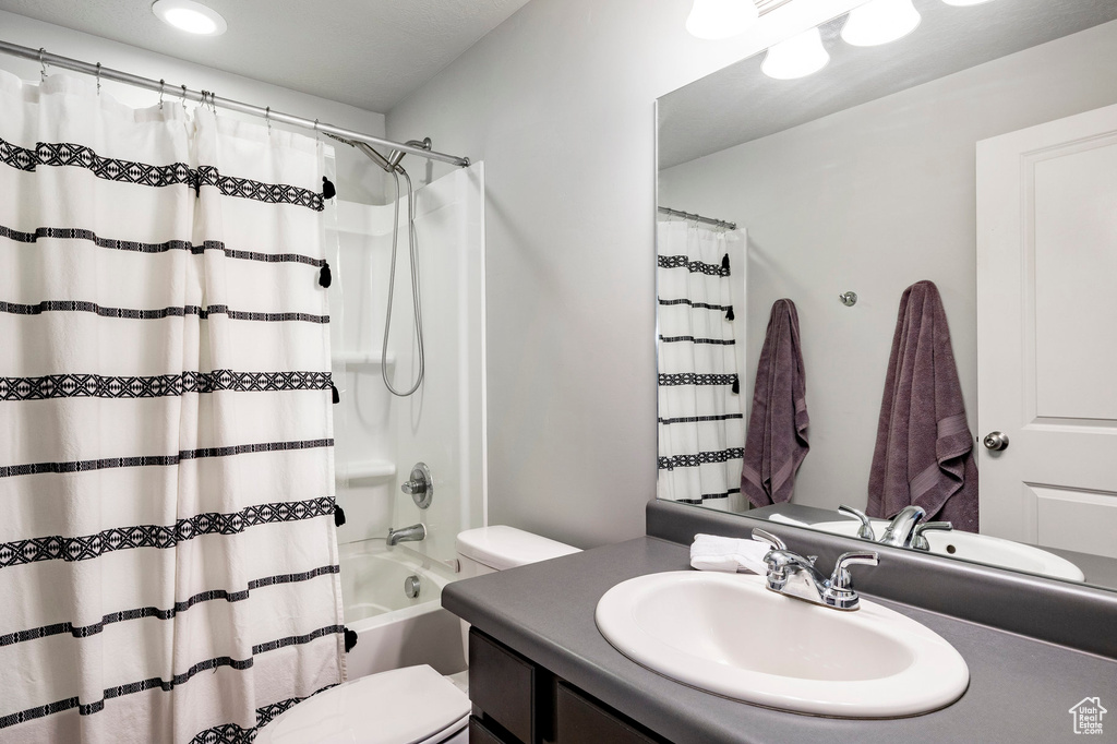 Full bath featuring toilet, vanity, shower / tub combo, and recessed lighting
