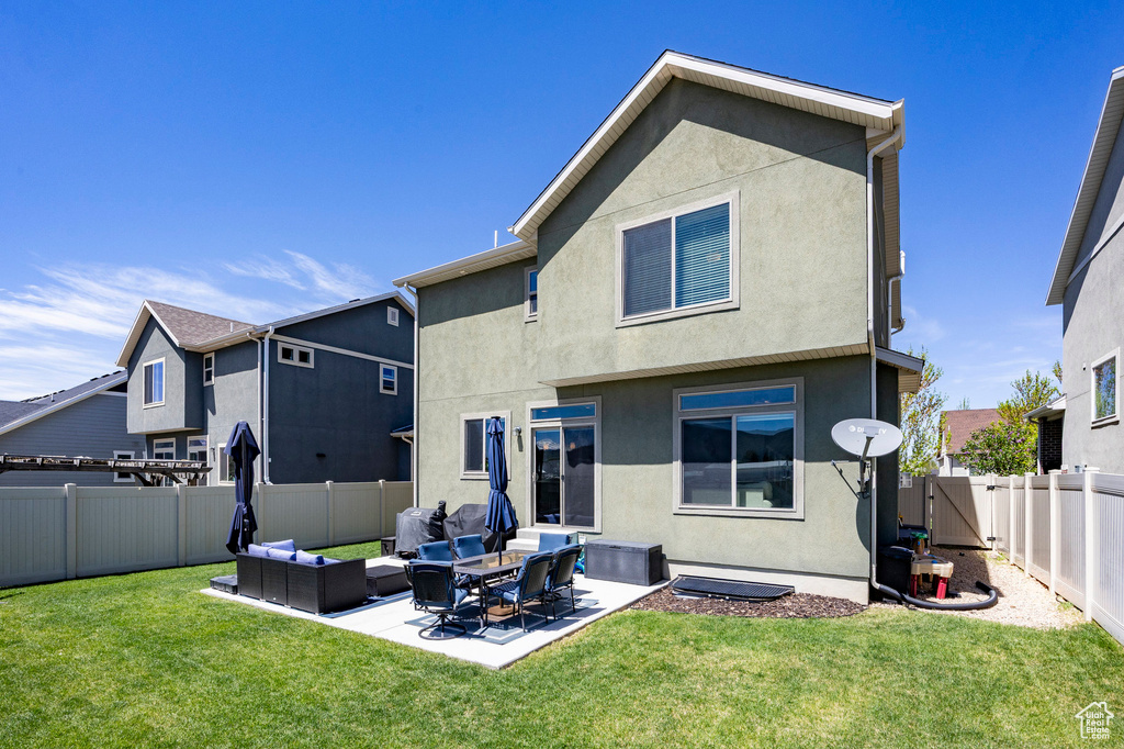 Rear view of house with an outdoor living space, stucco siding, and a patio area