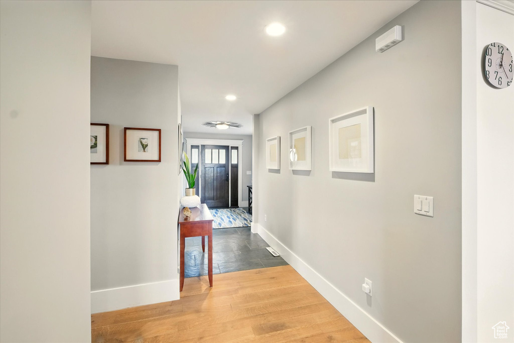 Hall with baseboards, recessed lighting, and wood finished floors