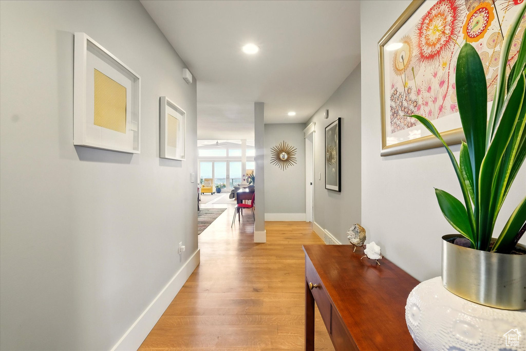 Hall featuring light wood-type flooring, baseboards, and recessed lighting