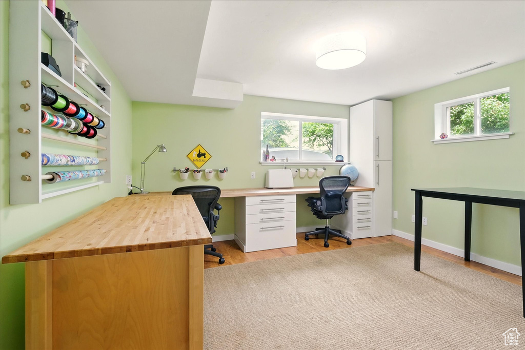 Home office featuring plenty of natural light and light wood-type flooring