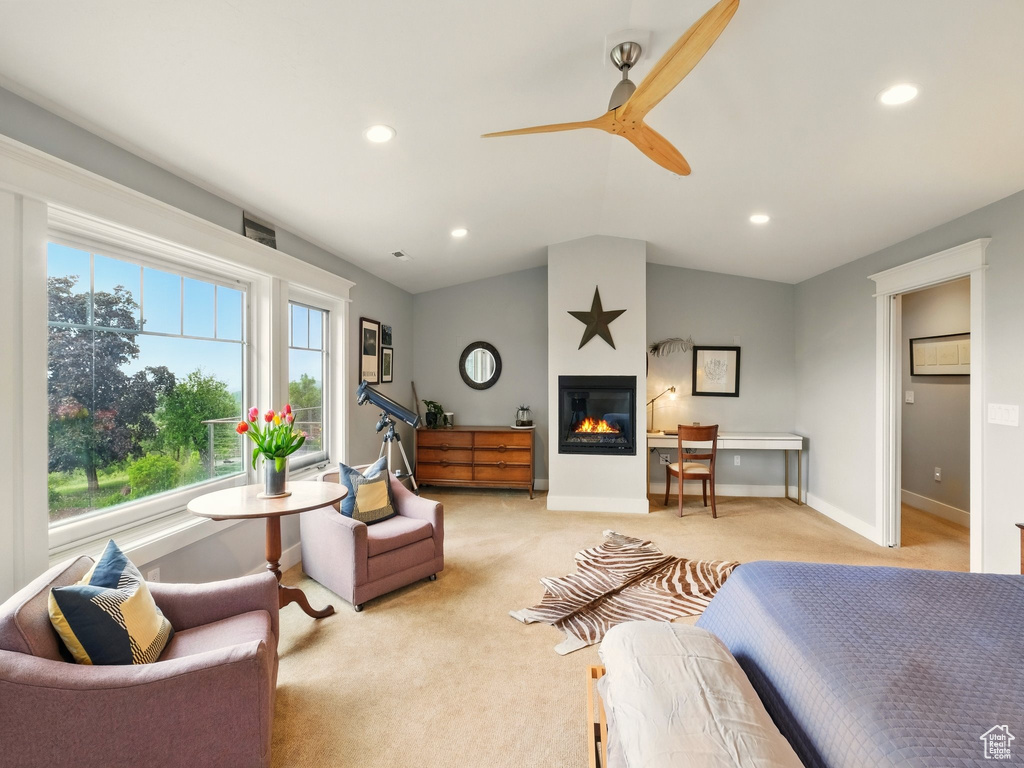 Bedroom with light colored carpet, a glass covered fireplace, recessed lighting, lofted ceiling, and ceiling fan