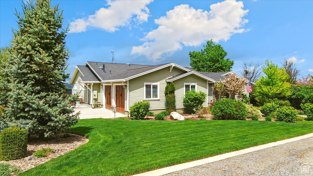 View of front of home with a front lawn and roof with shingles