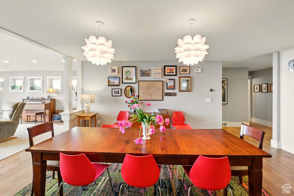 Dining space featuring wood finished floors, decorative columns, recessed lighting, and baseboards