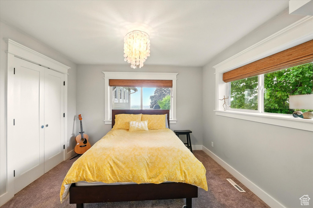 Bedroom with multiple windows, carpet flooring, a chandelier, and baseboards