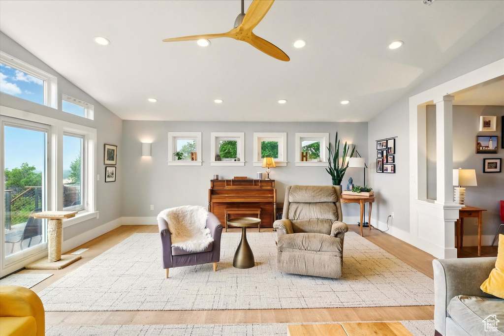 Living area with lofted ceiling, light wood finished floors, recessed lighting, ceiling fan, and baseboards