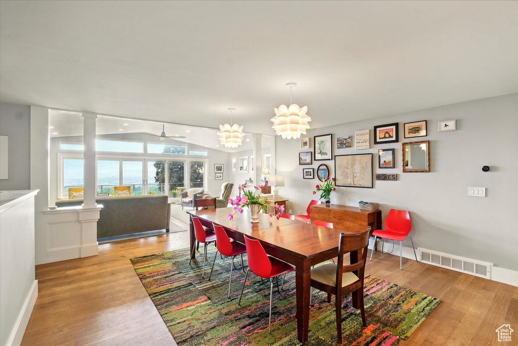 Dining space with light wood-type flooring, decorative columns, baseboards, and a ceiling fan