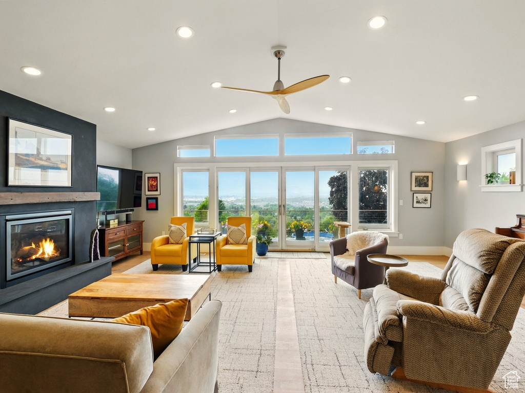 Living room with vaulted ceiling, a fireplace, recessed lighting, a ceiling fan, and healthy amount of natural light