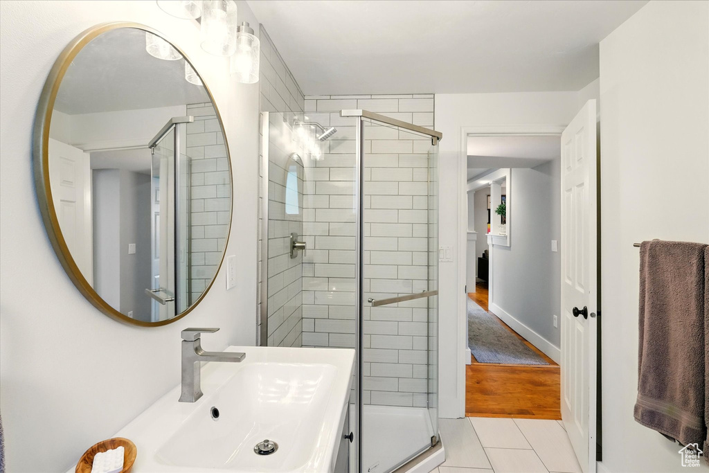 Full bathroom featuring a shower stall, tile patterned flooring, and vanity