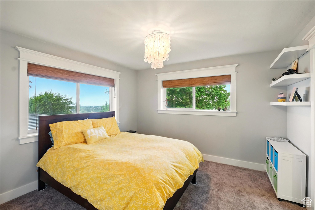 Bedroom featuring baseboards, a chandelier, and carpet floors
