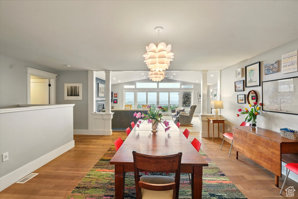 Dining area with light wood finished floors, baseboards, and a chandelier