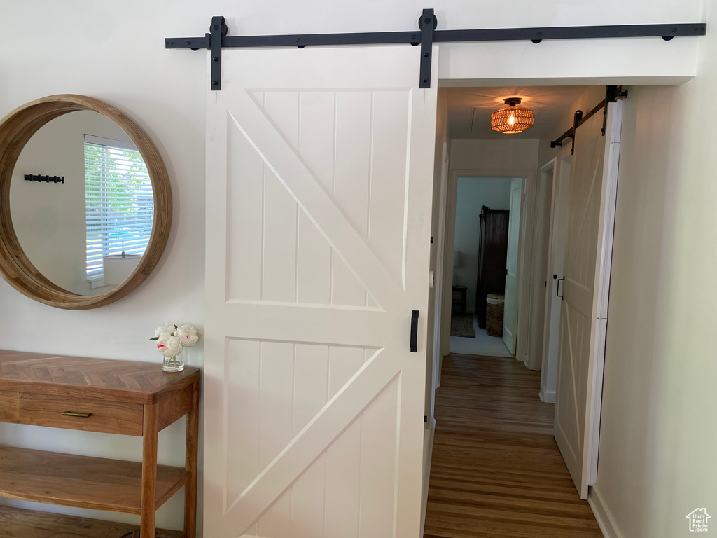 Hallway featuring a barn door and wood finished floors