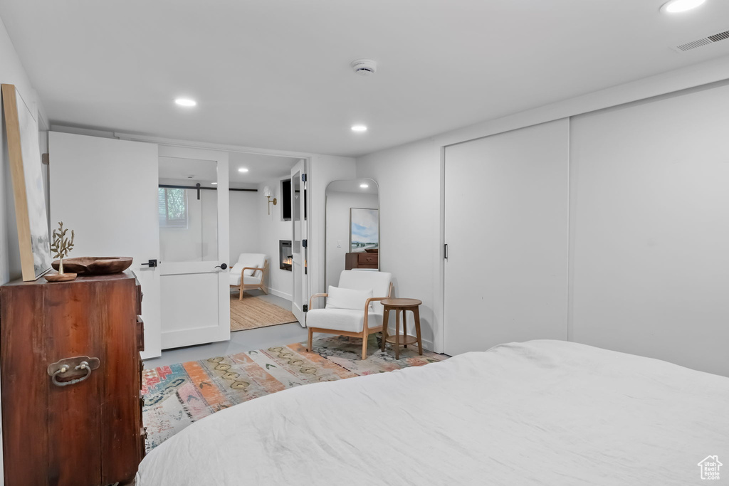 Bedroom with recessed lighting, a closet, connected bathroom, and wood finished floors