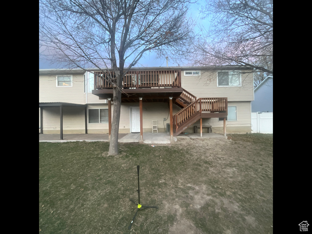 Back of house with a deck, fence, stairs, and a patio