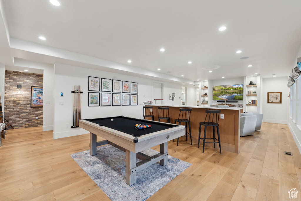 Rec room with billiards table, recessed lighting, light wood finished floors, brick wall, and bar with sink