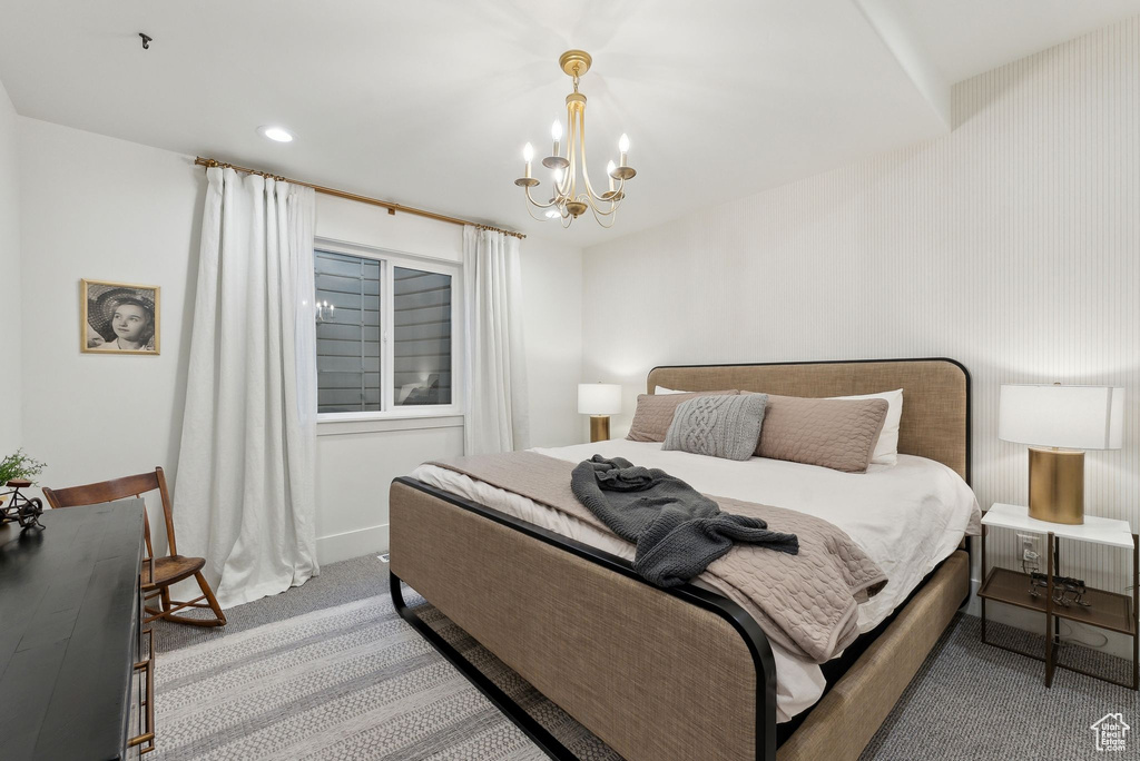Bedroom featuring light colored carpet and a chandelier