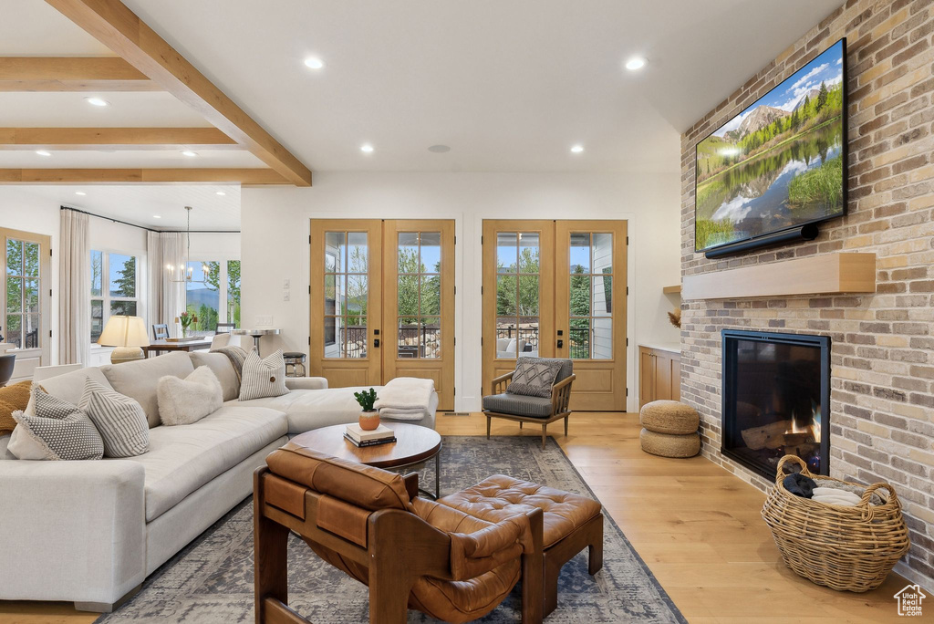 Living area with wood finished floors, recessed lighting, a fireplace, french doors, and a wainscoted wall