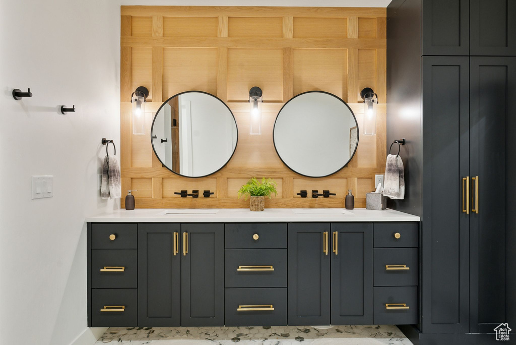 Bathroom with double vanity and baseboards