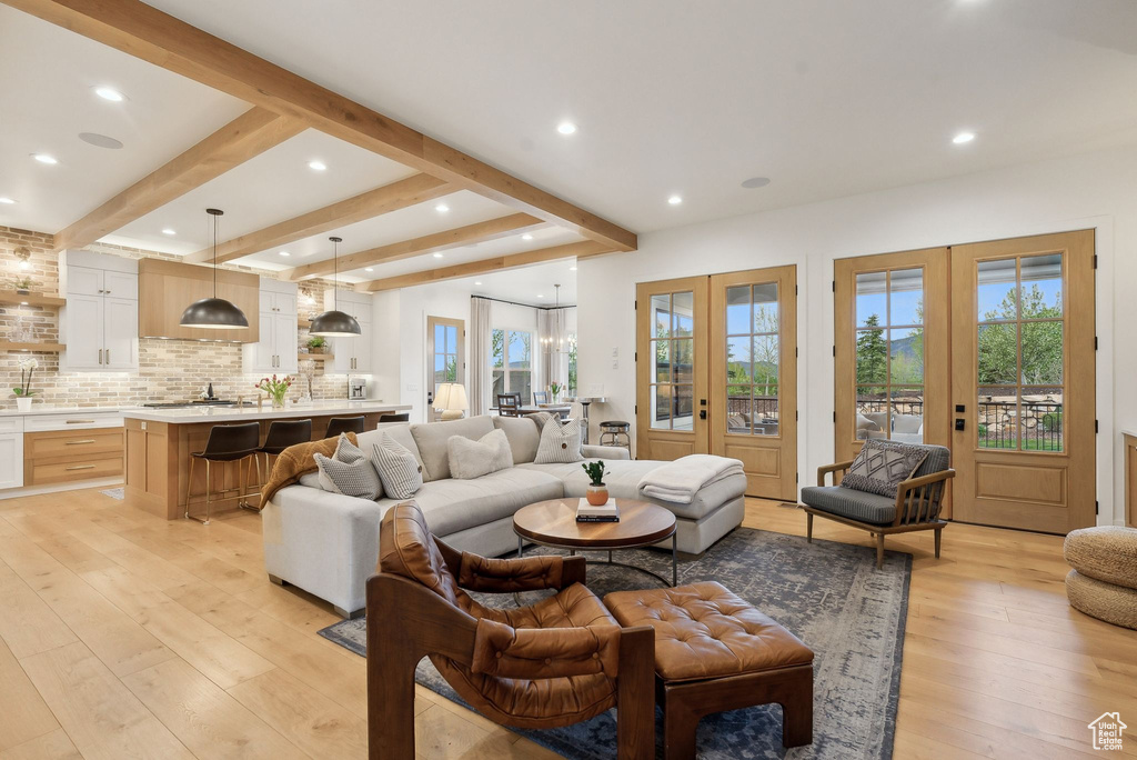 Living area featuring french doors, light wood-style floors, recessed lighting, and beamed ceiling