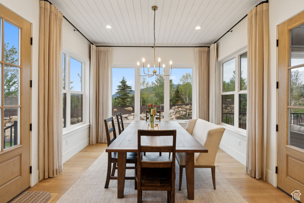 Dining space with a chandelier, wood ceiling, healthy amount of natural light, light wood finished floors, and recessed lighting