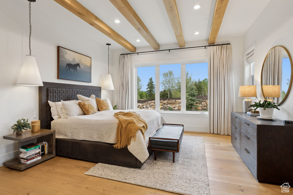 Bedroom with beamed ceiling, light wood-style floors, recessed lighting, and baseboards