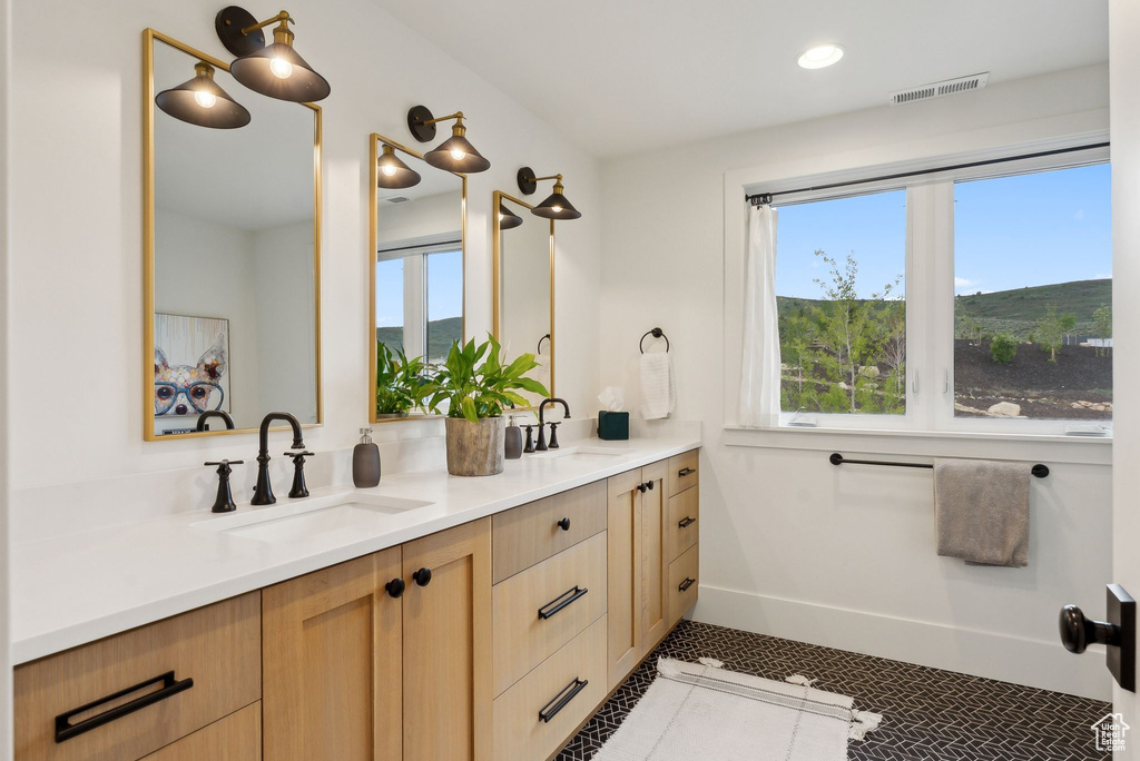 Full bath featuring double vanity, tile patterned flooring, baseboards, and recessed lighting