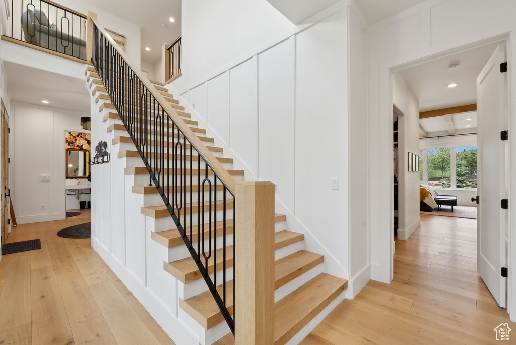 Staircase with hardwood / wood-style floors, recessed lighting, and baseboards