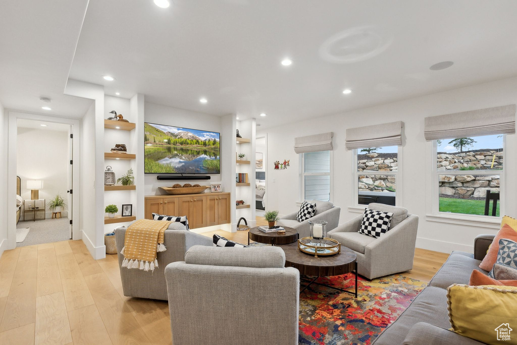 Living area with light wood-style floors, recessed lighting, and built in shelves