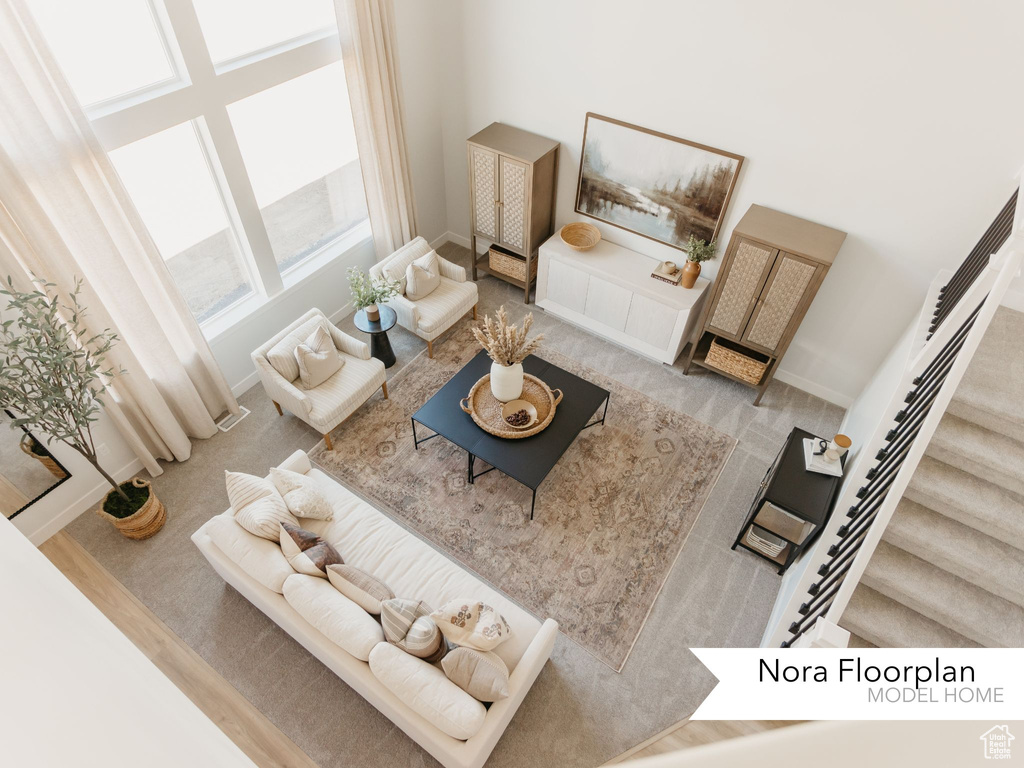 Living area featuring stairs, baseboards, and a high ceiling