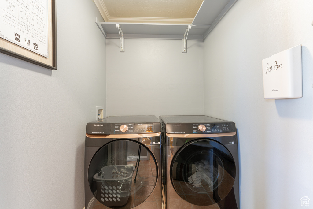 Washroom with crown molding and washing machine and dryer